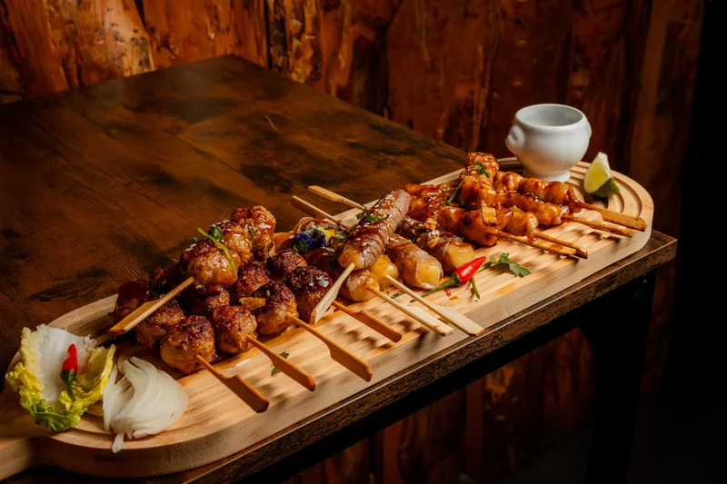 Planche de brochettes grillées servie sur une table en bois