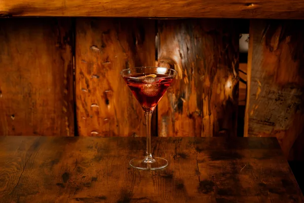 Cocktail rouge servi dans un verre à pied